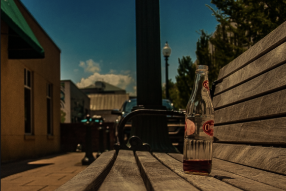 A Cheerwine bottle sits on a bench