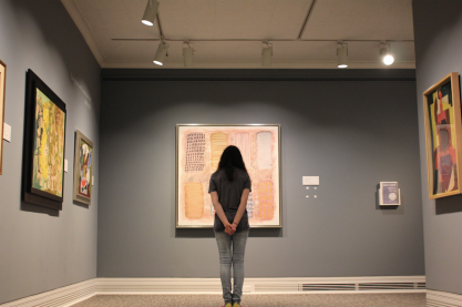 A girl stares at a painting.